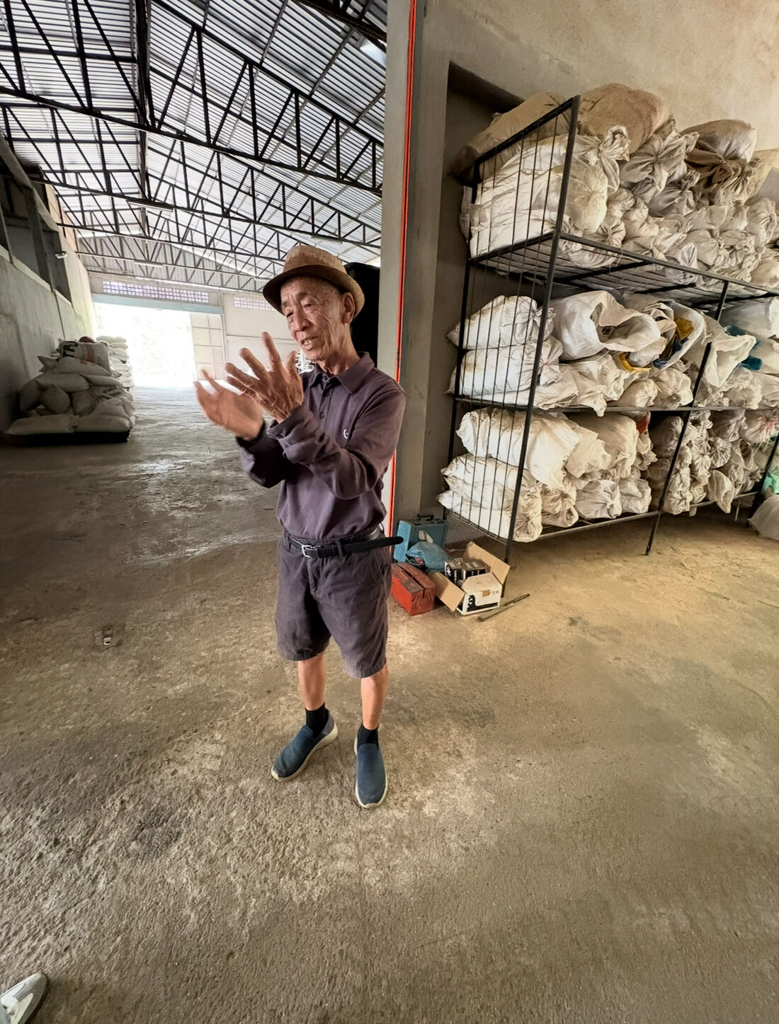 Productor en el almacén junto a los sacos de café